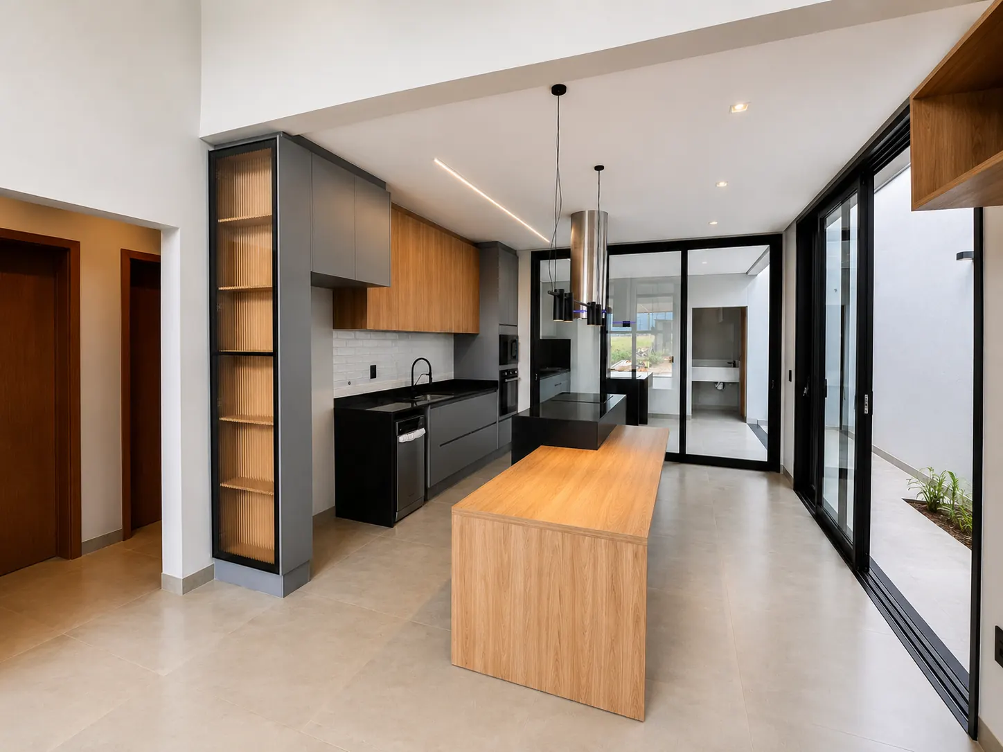 Cozinha com bancada preta, armários cinza e portas de vidro